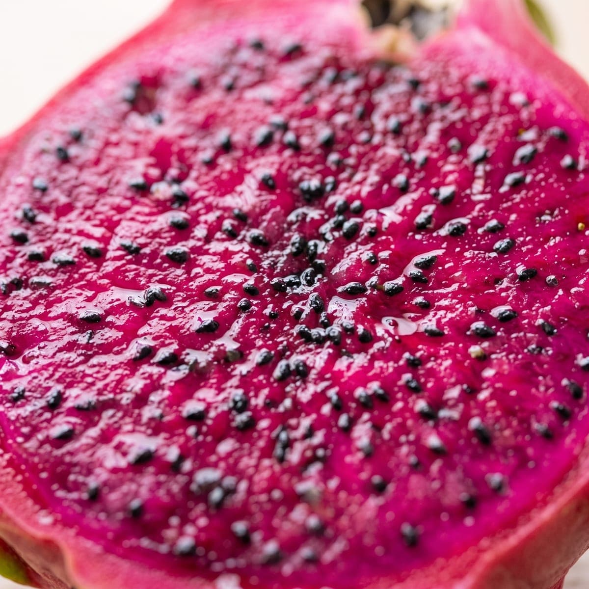 Close da polpa magenta da pitaya, cheia de sementinhas pretas